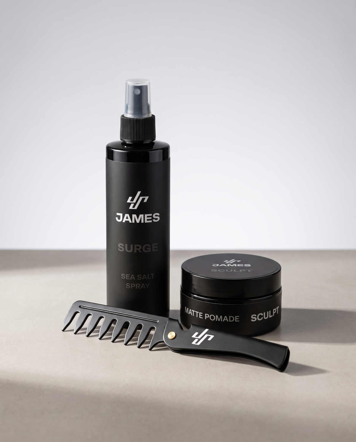 Surge sea salt spray, Sculpt matte pomade en de Flow comb naast elkaar in een lichte studio